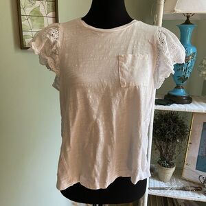 White t-shirt with pocket on front, back is lace-like material.
